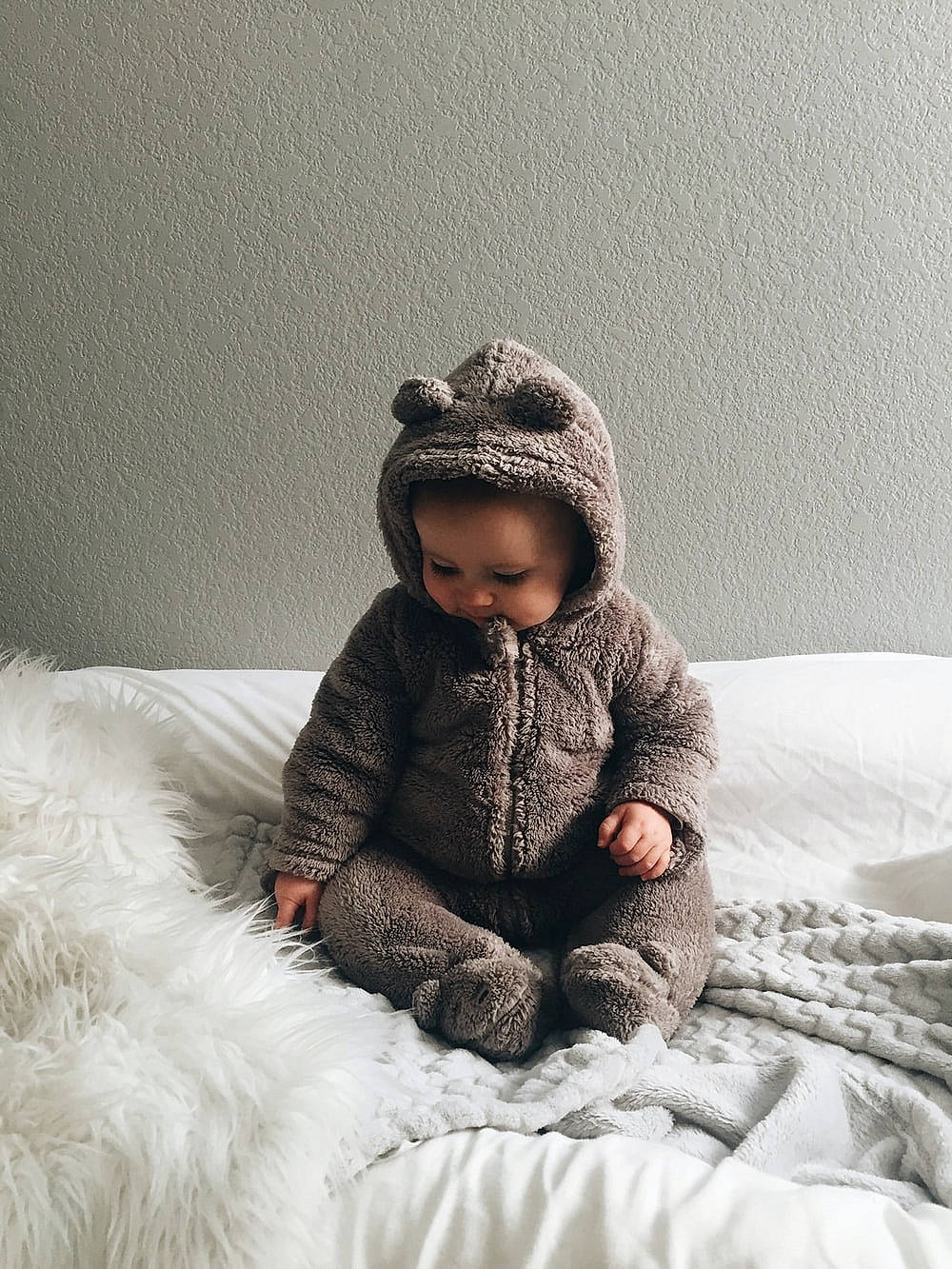 James is registered to the contest to win money with this photo: art, baby, baby_toddler_clothing, cap, child, comfort, flash_photography, flooring, fur, grey, happy, linens, outerwear, person, room, sitting, skin, sleeve, smile, toddler