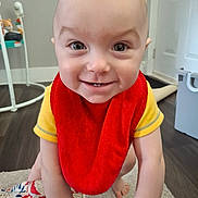Marley joined the competition — help win amazing prizes! baby, child, smiling, red_bib, yellow_shirt, crawling, indoor, floor, carpet, toy, face, person, happy, young_child, home, light_skin, cute, expression, closeup, infant