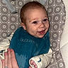 Augustus is registered to the contest to win money with this photo: baby, child, infant, smiling, happy, portrait, bouncer, baby_seat, safety_straps, patterned_fabric, blue_clothing, cream_clothing, hand, adult_hand, indoor, close_up, seated, brown_hair, face, photograph