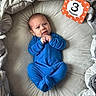 Augustus joined the competition — help win amazing prizes! baby, infant, child, three_months, blue_onesie, lying_down, bed, blanket, bedding, portrait, face, eyes, hands, fists, smiling, indoor, milestone_card, orange_sign, cozy, photography
