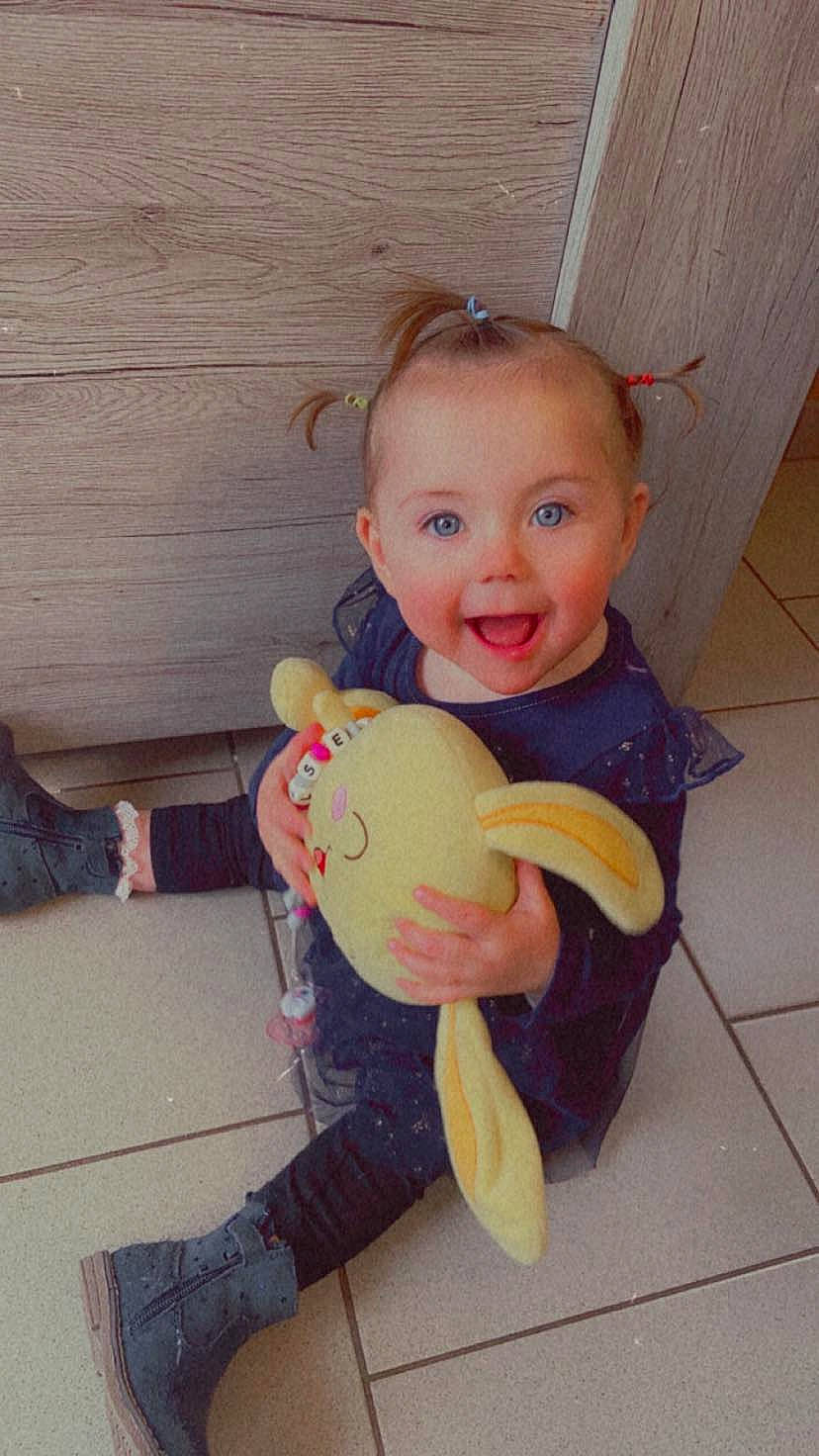 Chelsea a rejoint le concours — aidez-le/la à gagner de superbes lots ! baby, baby_products, baby_toddler_clothing, baby_toys, cheek, child, eye, flooring, fun, happy, head, person, sitting, skin, smile, stuffed_toy, t_shirt, thumb, toddler, toy