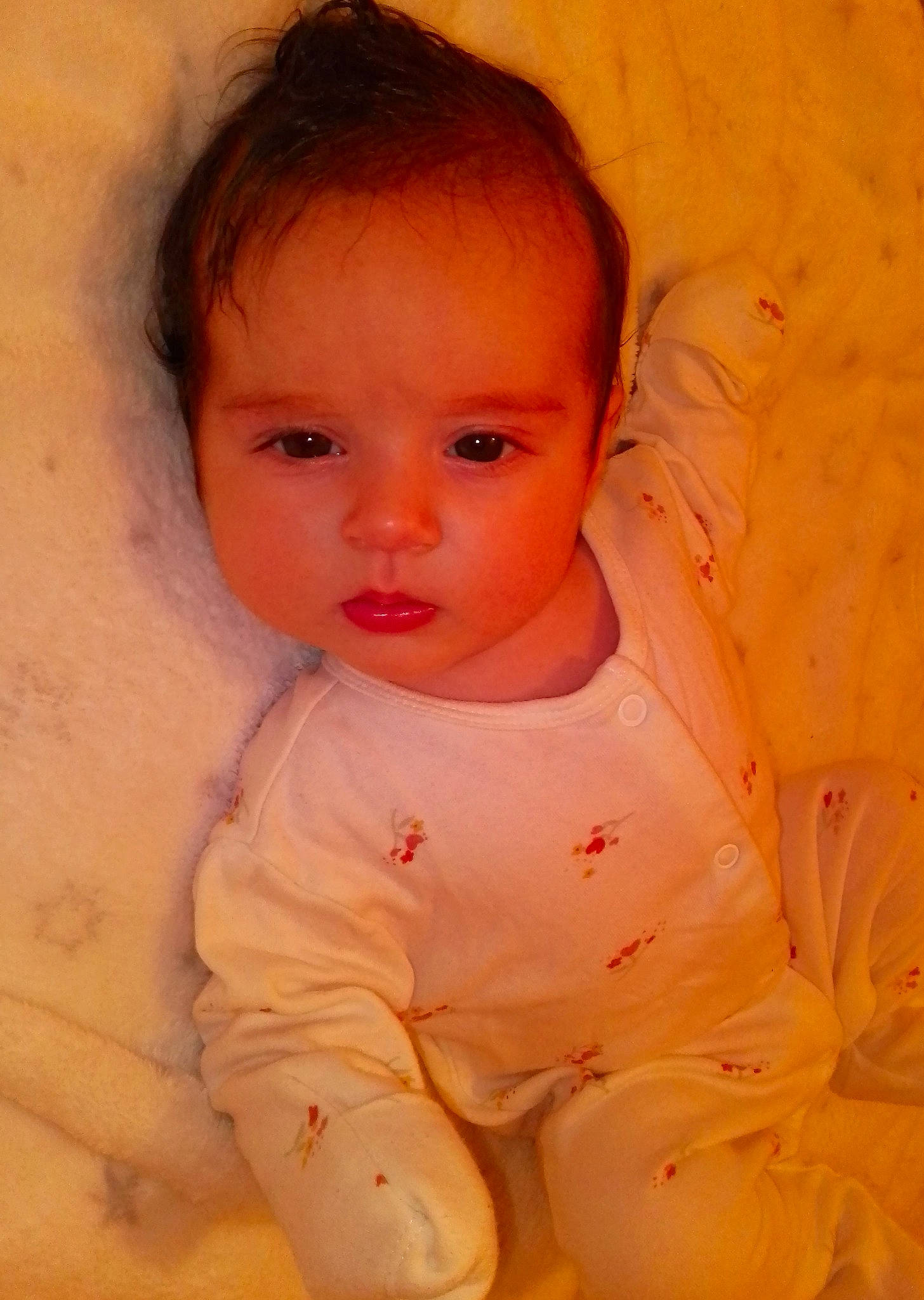 Amira is registered to the contest to win money with this photo: arm, baby, baby_toddler_clothing, cheek, chest, chin, comfort, eyebrow, eyelash, gesture, happy, human_body, iris, linens, lip, nose, peach, person, skin, sleeve