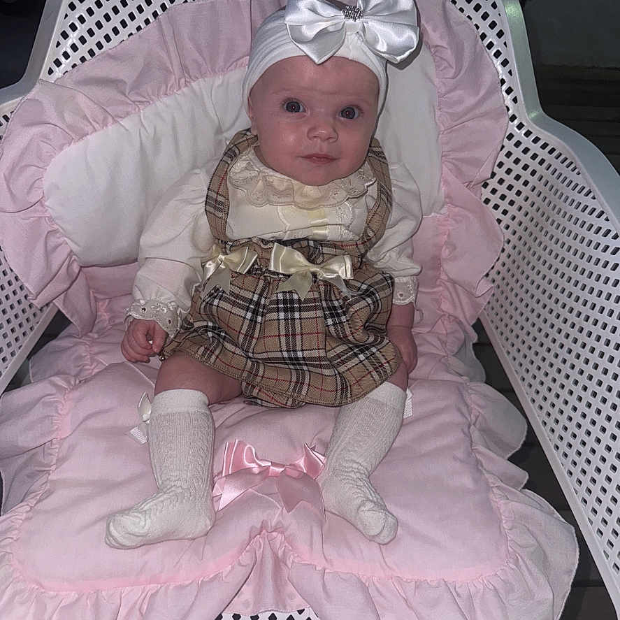 Rayah-Rose is registered to the contest to win money with this photo: adorable, baby, baby_fashion, child, clothing, cute, fabric, headband, indoor, infant, looking_at_camera, person, pink_cushion, plaid_dress, portrait, seated, white_bow, white_chair, white_socks, young_child