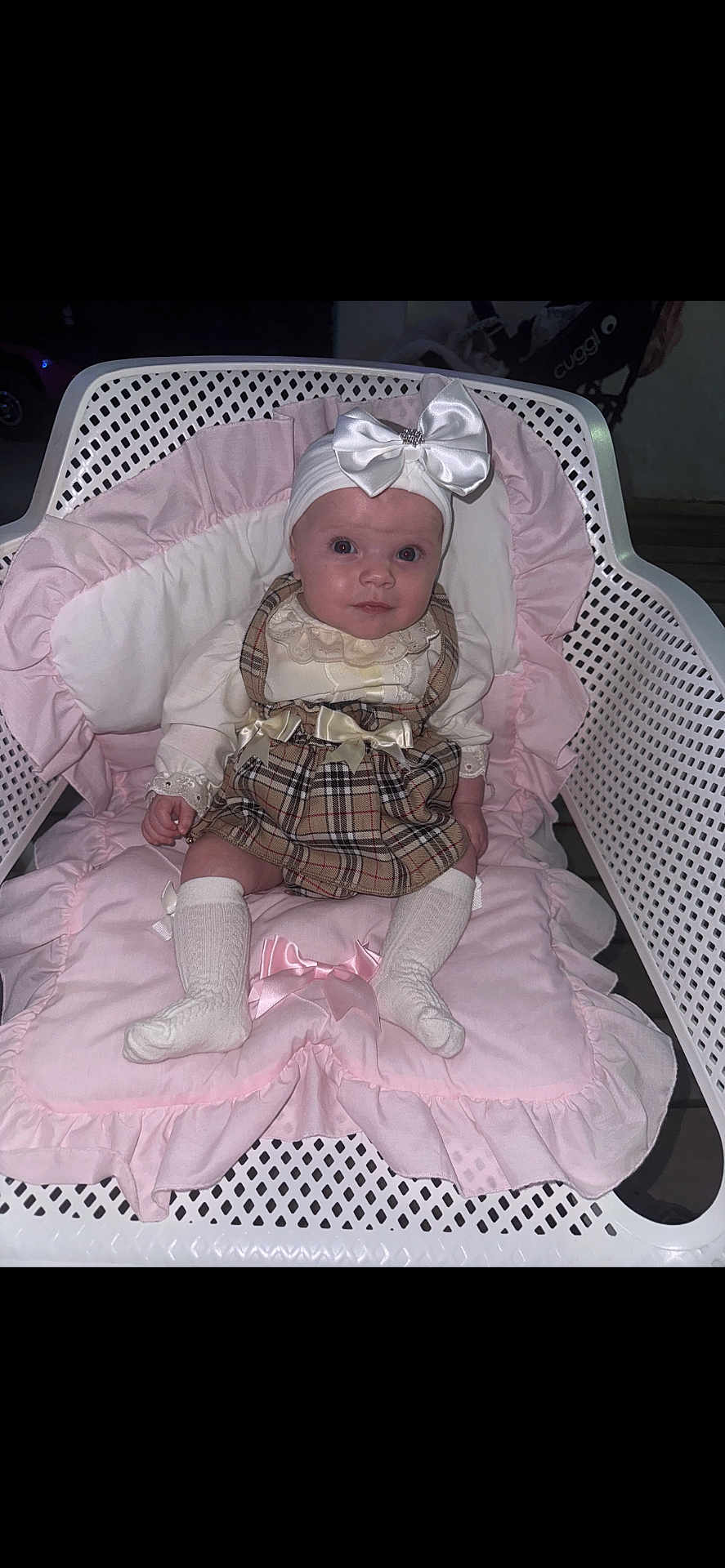 Rayah-Rose is registered to the contest to win money with this photo: baby, child, infant, white_bow, plaid_dress, white_socks, pink_cushion, white_chair, indoor, portrait, cute, adorable, seated, looking_at_camera, headband, fabric, clothing, person, young_child, baby_fashion