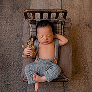 Colton joined the competition — help win amazing prizes! newborn, baby, sleeping, teddy_bear, wooden_bed, pillows, knit_overalls, carpet, indoors, cozy, cute, infant, peaceful, resting, relaxed, child, soft_lighting, portrait, tiny_bed, floor