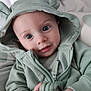 baby, hoodie, green_clothing, child, cute, hands, face, eyes, infant, portrait, sitting, indoor, soft_light, casual_wear, young_child, hood, zipper, small_hands, cozy, expression