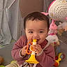 baby, chewing, child, clothing, colorful, cute, floor, indoor, infant, mesh, pink, playpen, playtime, sitting, soft_toys, stuffed_animal, teddy_bear, toy, trumpet, yellow