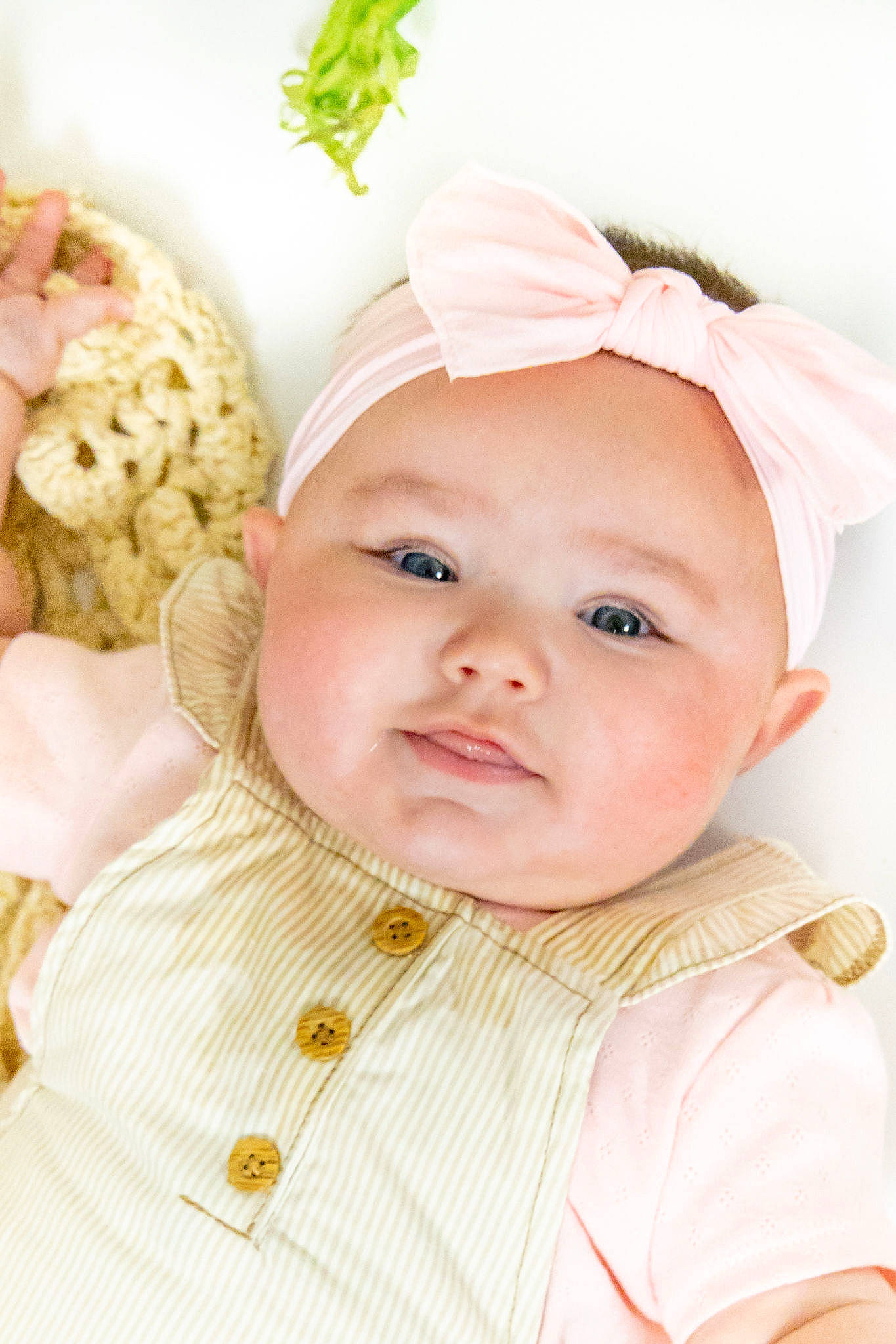 Arya is registered to the contest to win money with this photo: baby, baby_toddler_clothing, cheek, child, collar, dress, face, fashion_accessory, happy, headband, headgear, headpiece, headwear, lip, pattern, person, pink, skin, sleeve, smile