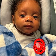 Aidyn joined the competition — help win amazing prizes! baby, infant, child, portrait, face, eyes, sleepy, seated, blanket, blue_blanket, white_clothing, pacifier, red_pacifier, padded_seat, cozy, indoor, close_up, photography, baby_carrier, calm