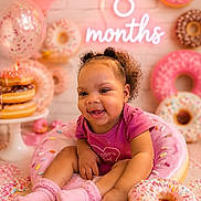 Serenity joined the competition — help win amazing prizes! baby, child, infant, pink, donut, sprinkles, balloon, smile, cute, happy, celebration, props, neon_sign, socks, curly_hair, sitting, food_theme, birthday, milestone, playful