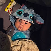 Shai a rejoint le concours — aidez-le/la à gagner de superbes lots ! baby, child, car_seat, hoodie, blanket, blue, cute, infant, face, eyes, clothing, portrait, sitting, cozy, warm, indoor, soft_lighting, fabric, bundle, kid