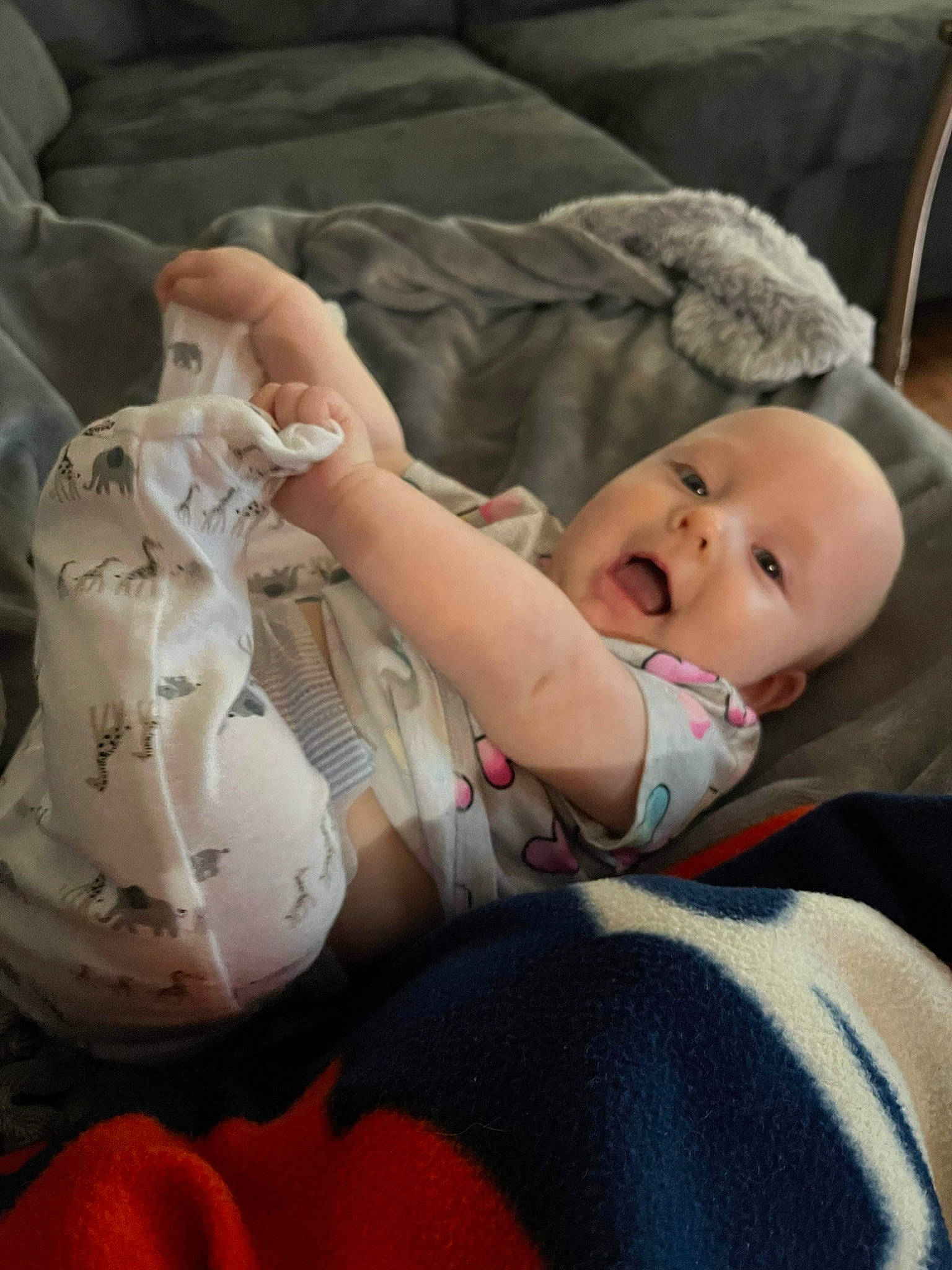 Phoenix is registered to the contest to win money with this photo: baby, baby_products, baby_toddler_clothing, carmine, cheek, child, comfort, facial_expression, head, human_leg, knee, linens, person, room, sitting, skin, sleeve, textile, thigh, toddler