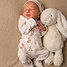 Keyleigh is registered to the contest to win money with this photo: baby, newborn, sleeping, plush_toy, bunny, stuffed_animal, portrait, indoors, cozy, onesie, hat, infant, peaceful, bed, blanket, soft_lighting, textile, nursery, cute, resting