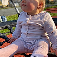 Atena participe au concours pour gagner de l'argent avec cette photo : baby, child, playground, rope_net, outdoor, sunlight, pink_pajamas, footwear, sitting, face, grass, fence, house, sky, daytime, playing, cute, young_child, casual_clothing, expression