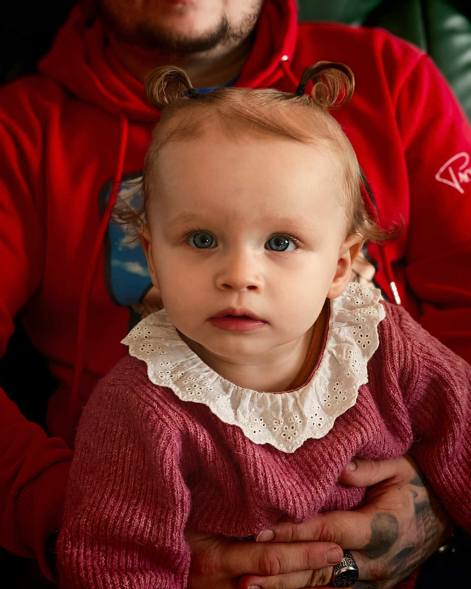 Cataleya a rejoint le concours — aidez-le/la à gagner de superbes lots ! toddler, child, baby, person, portrait, blue_eyes, pigtails, sweater, knitwear, lace_collar, adult, hands, tattoo, ring, red_hoodie, closeup, indoor, warm_lighting, expression, curious