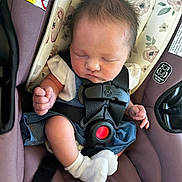 Ellie is registered to the contest to win money with this photo: baby, sleeping, car_seat, safety_harness, white_socks, clothing, infant, cute, peaceful, face, head, hair, child, seat, fabric, pattern, comfort, rest, toddler, hands