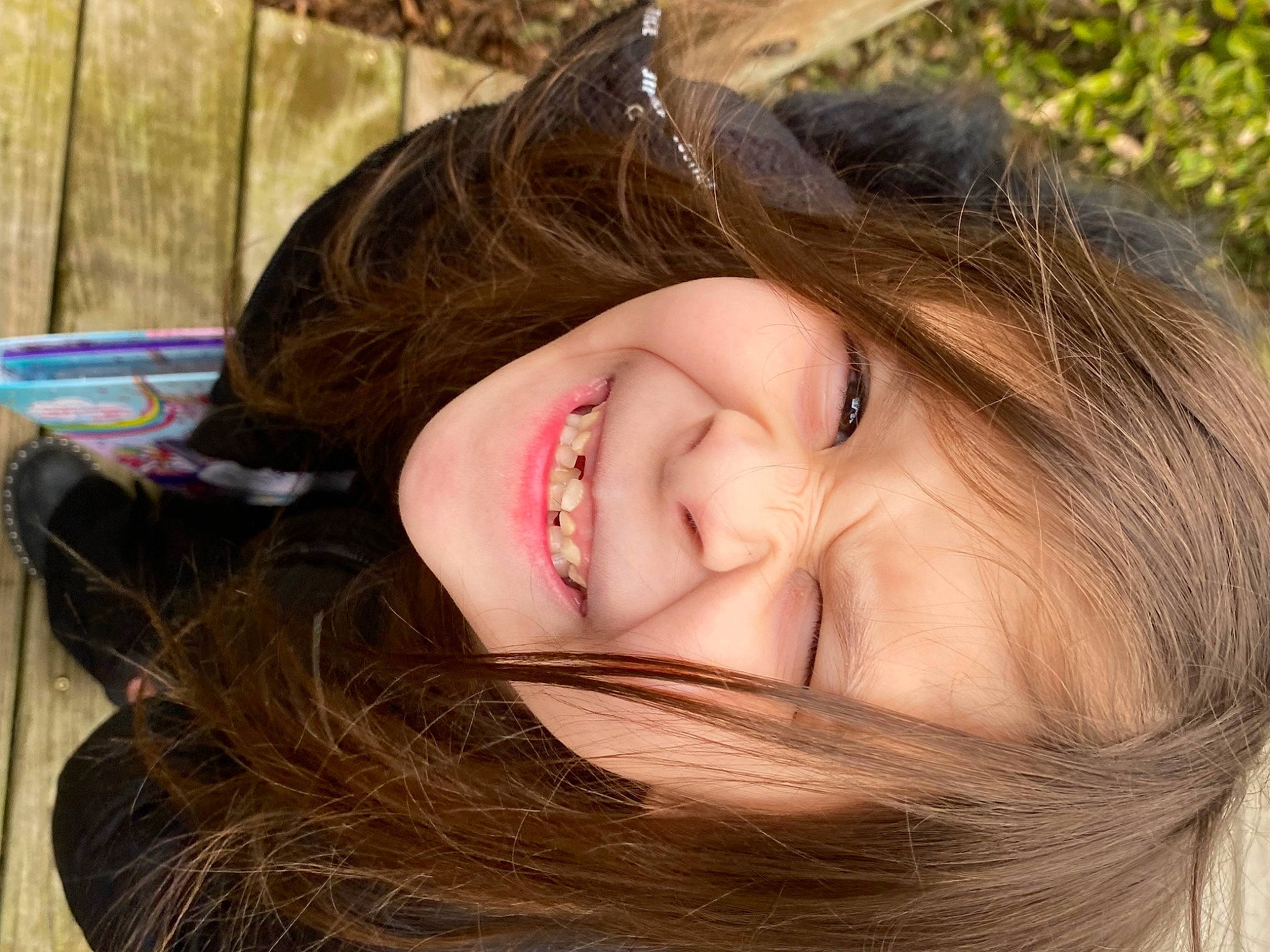 Jenna joined the competition — help win amazing prizes! black_hair, cheek, close_up, eyelash, forehead, grass, happy, iris, jaw, layered_hair, lip, long_hair, neck, nose, person, plant, skin, smile, toddler, tree