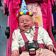 Oakleigh Mae joined the competition — help win amazing prizes! baby, birthday_hat, stroller, pink, smiling, pacifier, striped_pants, white_sweater, happy, infant, child, seat_belt, indoor, flamingo_pattern, sun_pattern, celebration, colorful, toy, cute, playful