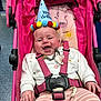 baby, birthday_hat, stroller, pink, smiling, pacifier, striped_pants, white_sweater, happy, infant, child, seat_belt, indoor, flamingo_pattern, sun_pattern, celebration, colorful, toy, cute, playful