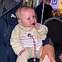 baby, child, infant, person, sitting, clothing, hand, face, blue_eyes, pacifier_clip, indoor, adult_hand, chair, table, light, room, blurred_background, striped_shirt, knitwear, curious_expression