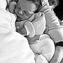 baby, newborn, sleeping_baby, infant, knit_sweater, blanket, hand, closed_eyes, face, hair, button, sock, parent_hand, watch, car_seat, cushion, black_and_white, portrait, cozy, closeup