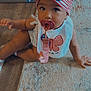 Zariyah is registered to the contest to win money with this photo: toddler, child, pacifier, headband, bow, bib, butterfly, carpet, rug, floor, indoor, curly_hair, clothing, sitting, baby, person, cute, looking_up, infant, home