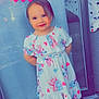 toddler, child, dress, barefoot, smiling, heart_emoji, glass_door, floor, tile, curtain, indoor, cartoon_print, pink_hearts, happy, standing, cute, girl, portrait, colorful, casual