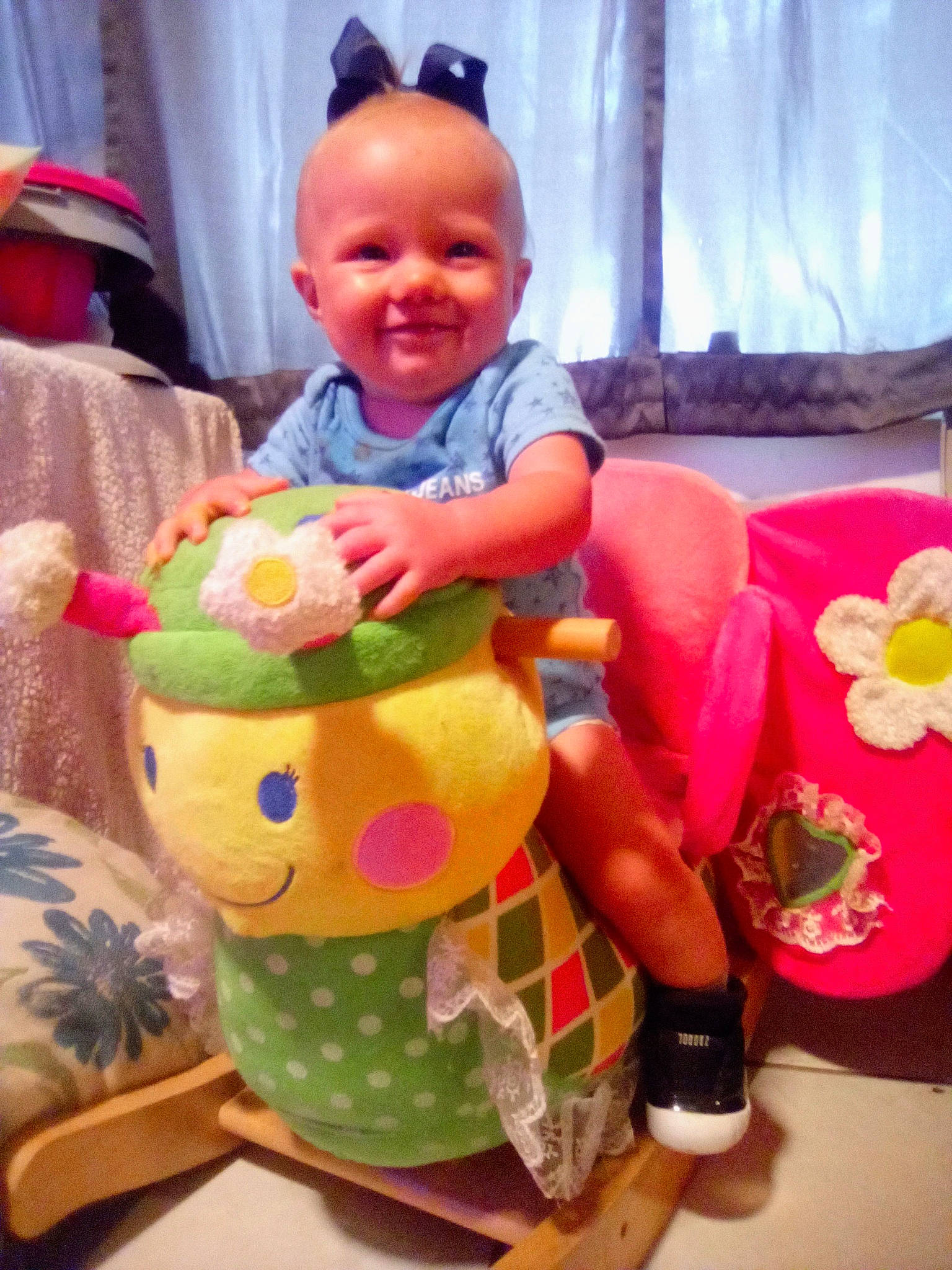 Mallorie is registered to the contest to win money with this photo: baby, baby_products, baby_toddler_clothing, baby_toys, child, curtain, facial_expression, fun, happy, head, joy, leisure, pattern, person, pink, play, room, sitting, smile, t_shirt