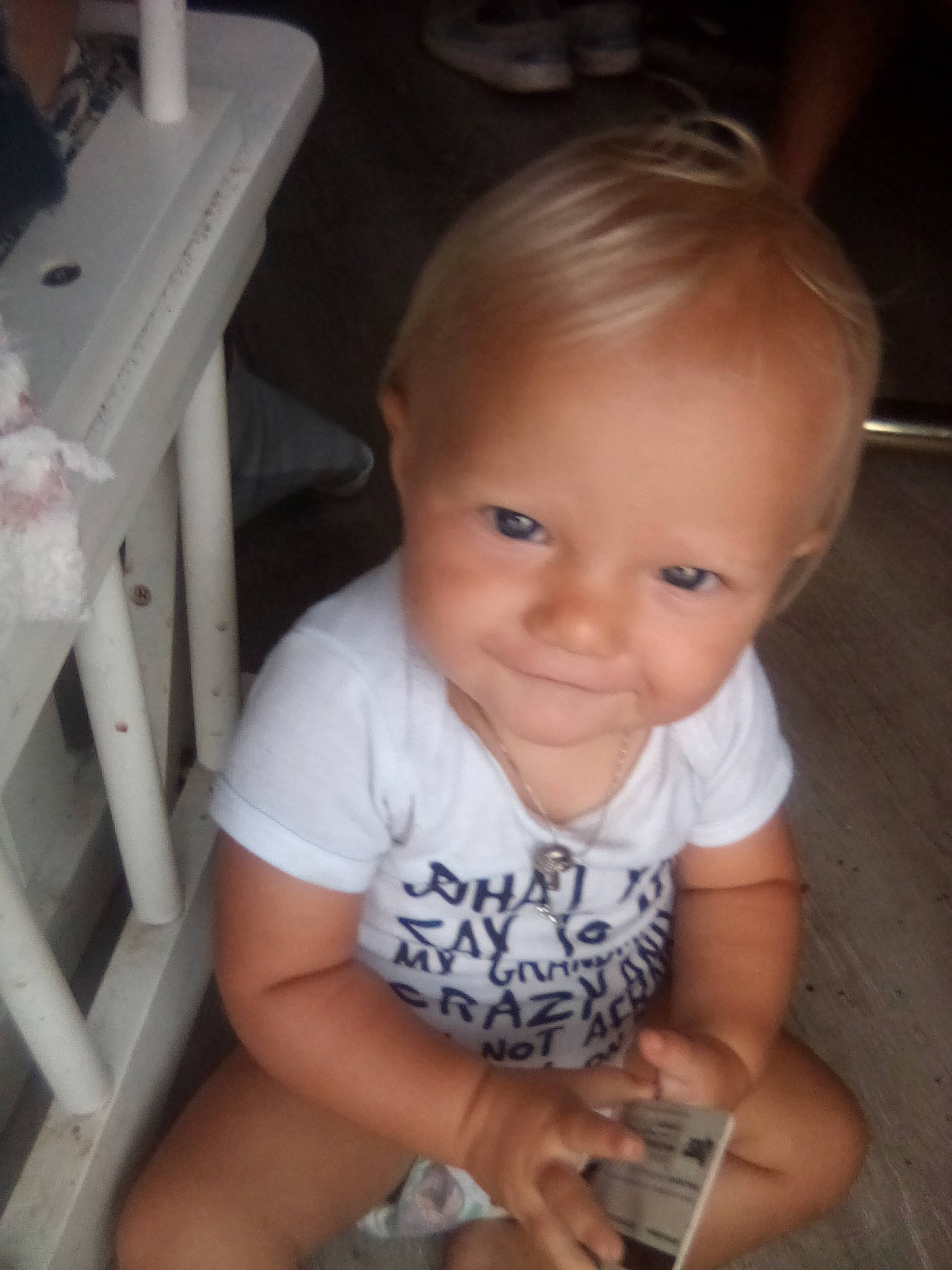 Mallorie joined the competition — help win amazing prizes! baby_toddler_clothing, blond, cheek, child, eye, face, finger, flooring, hair, hand, happy, iris, mouth, nose, person, sitting, skin, smile, t_shirt, thumb
