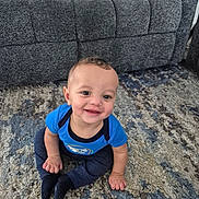 Caius joined the competition — help win amazing prizes! baby, child, smiling, blue_shirt, carpet, couch, indoor, sitting, happy, person, young_child, cute, face, portrait, floor, home, clothing, infant, hands, feet