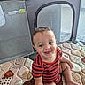 Caius joined the competition — help win amazing prizes! toddler, child, baby, smiling, striped_clothing, playpen, playmat, indoor, happy, cute, sitting, young_child, patterned_mat, curly_hair, barefoot, infant, person, home, comfort, casual
