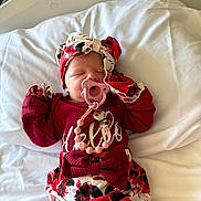 Layna joined the competition — help win amazing prizes! newborn, baby, pacifier, headband, floral_clothing, sleeping, bed, hospital, blanket, infant, cute, child, person, pink, red, white, lying_down, clothing, accessory, sleep