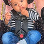 baby, child, car_seat, headband, striped_shirt, jeans, socks, sitting, hands, face, eyes, black_hair, curly_hair, safety_harness, infant, cute, indoor, young_child, portrait, clothing