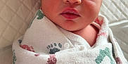 Royal is registered to the contest to win money with this photo: newborn, baby, swaddled, blanket, footprints, infant, sleepy, cute, face, portrait, closeup, soft, cozy, quilted, wrapped, child, human, lying_down, indoors, resting