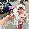 bench, child, flowers, hand, headband, hearts, holding_hand, jacket, outdoor, pavement, people, pink, planter, shoe, smile, storefront, street, sweater, toddler, window