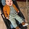 baby, brown_shoes, cardigan, cheeks, child, eyes, face, green_pants, hand, happy, indoor, jacket, knit_top, metal_table, portrait, seat, smile, sneakers, stroller, wood_floor
