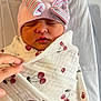 Eliana is registered to the contest to win money with this photo: newborn, baby, infant, swaddled, blanket, cherry_pattern, pink_hat, bow, sleeping, hand, white_background, soft_texture, cute, peaceful, portrait, indoor, child, face, person, closeup