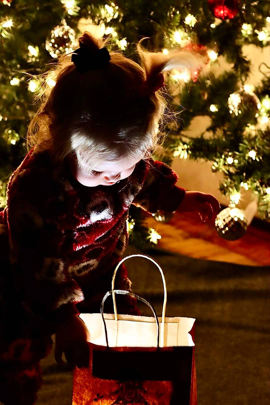 Valerie is registered to the contest to win money with this photo: christmas, christmas_decoration, christmas_eve, christmas_ornament, christmas_tree, conifer, event, fun, happy, holiday, holiday_ornament, interior_design, light, ornament, person, plant, sitting, tradition, tree, window