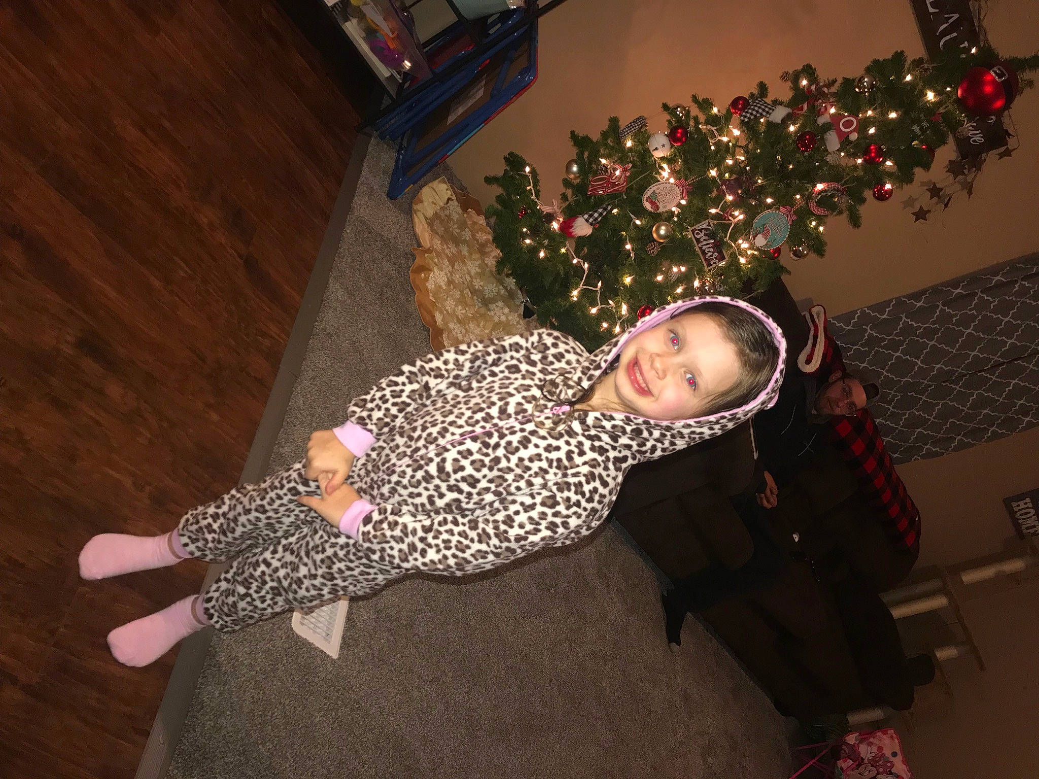 Addyson is registered to the contest to win money with this photo: baby_toddler_clothing, child, christmas, christmas_decoration, christmas_ornament, christmas_tree, event, flooring, fun, hardwood, headwear, holiday, joy, ornament, pattern, person, plant, room, smile, toddler