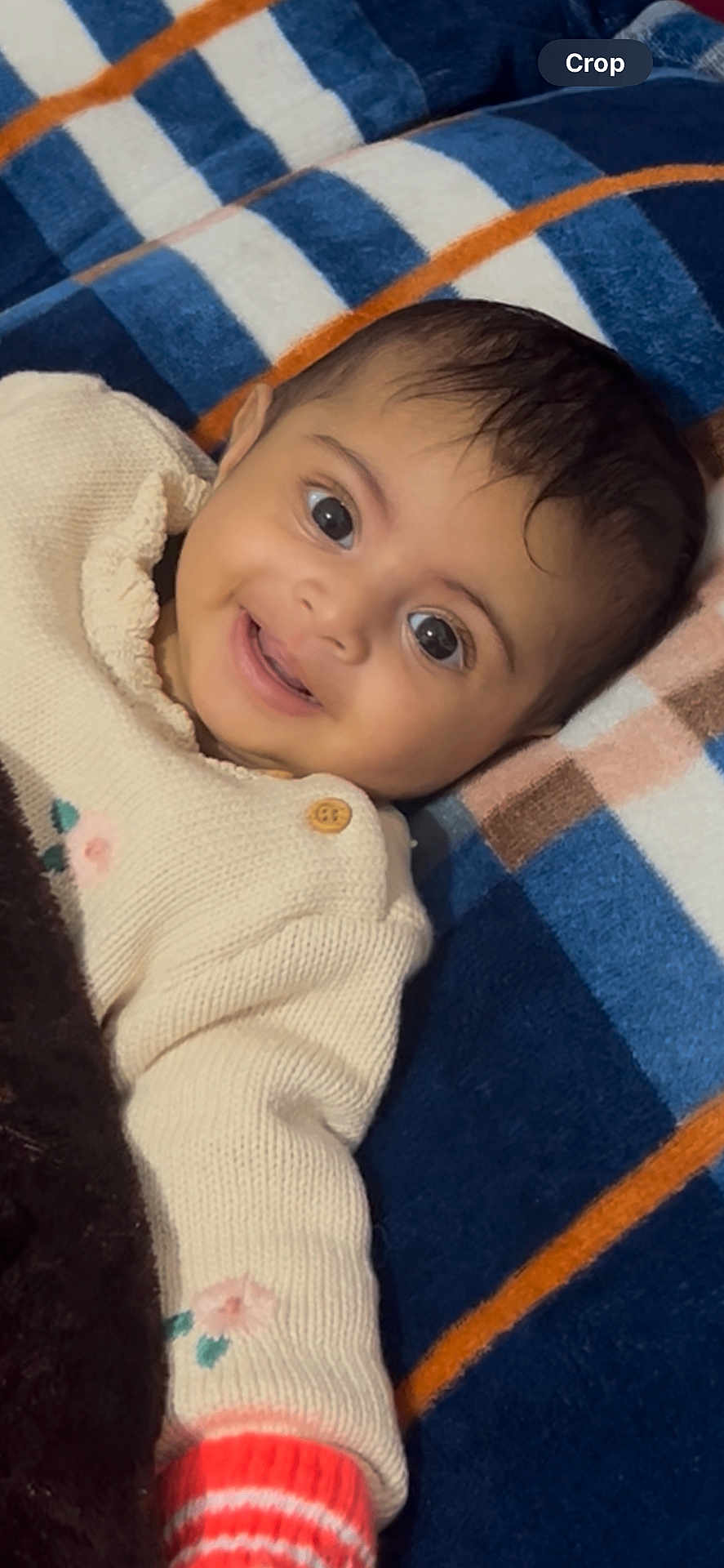 Rehmat Kaur joined the competition — help win amazing prizes! baby, blanket, cheerful, child, closeup, colorful, cozy, cute, face, happy, indoors, infant, knitted_clothing, lying_down, portrait, smiling, striped, sweater, warm, young_child