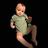 Dale is registered to the contest to win money with this photo: baby, child, infant, onesie, green_clothing, face, skin, legs, arms, barefoot, portrait, expression, studio_lighting, black_background, isolated, person, cute, young_child, sitting, looking_at_camera