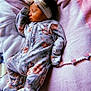 baby, sleeping, onesie, floral_pattern, headband, bow, blanket, soft_texture, infant, peaceful, closeup, indoors, cute, newborn, resting, toddler, child, comfort, lying_down, warm_lighting