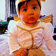 Kasiah joined the competition — help win amazing prizes! angel_costume, baby, celebration, child, closeup, costume, curtains, cute, expression, five_months, furniture, golden_wings, hand, headband, indoors, infant, portrait, sitting, white_dress, wooden_plaque