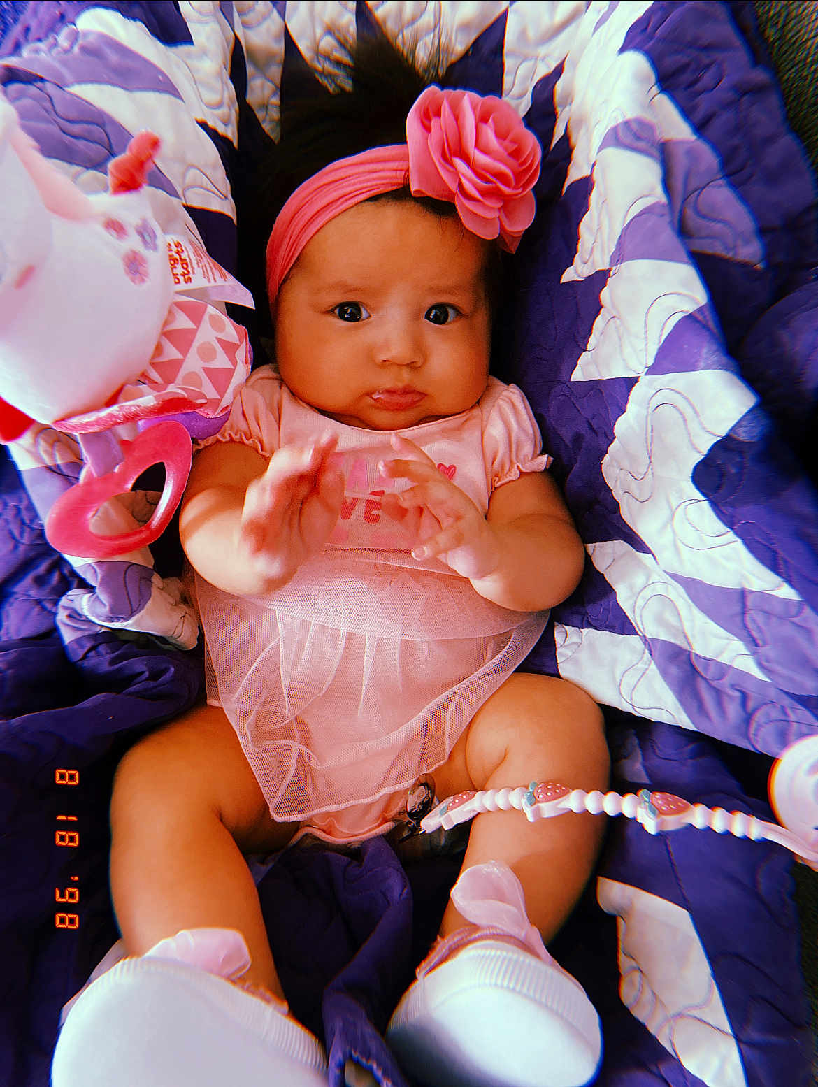 Kasiah joined the competition — help win amazing prizes! baby, infant, pink_headband, flower, pink_dress, purple_quilt, toy, white_shoes, cute, child, lying_down, hands, expression, curious, indoor, soft_toys, fabric, closeup, portrait, childhood