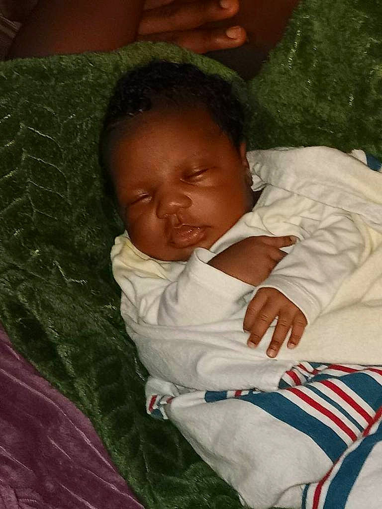 Bridgette is registered to the contest to win money with this photo: adaptation, baby, baby_products, baby_toddler_clothing, cheek, child, comfort, fun, grass, green, happy, lap, linens, nap, nose, person, room, sitting, skin, toddler