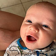 Aiden joined the competition — help win amazing prizes! baby, smiling, closeup, face, onesie, dinosaur_print, blue_trim, infant, happy, child, cute, portrait, human, skin, eyes, mouth, clothing, indoors, floor, tile