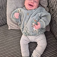 Cruz is registered to the contest to win money with this photo: baby, infant, smiling, happy, couch, striped, clothing, peter_rabbit, socks, sitting, cute, child, portrait, indoor, cozy, soft_fabric, playful, young, person, apparel