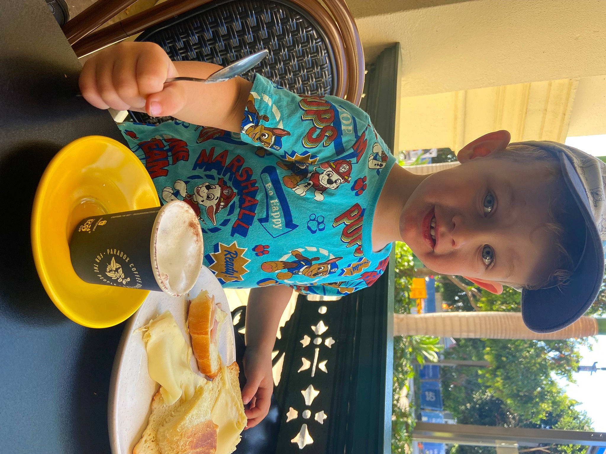 Elijah is registered to the contest to win money with this photo: arm, child, electric_blue, food, fun, hand, happy, hat, headgear, human_body, human_leg, joint, leisure, person, plate, shoulder, standing, tableware, thigh, toddler