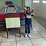 Davion is registered to the contest to win money with this photo: child, birthday_party, balloons, table, chairs, birthday_dude_shirt, jeans, sneakers, indoor, tile_floor, party_decorations, plates, cups, smiling, celebration, young_boy, window, blinds, colorful, happy
