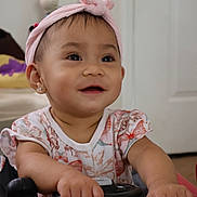 Felizia Rae joined the competition — help win amazing prizes! baby, child, smiling, headband, indoor, toy_car, hands, face, cute, happy, clothing, short_sleeves, pink, skin, earrings, person, infant, playtime, expression, young
